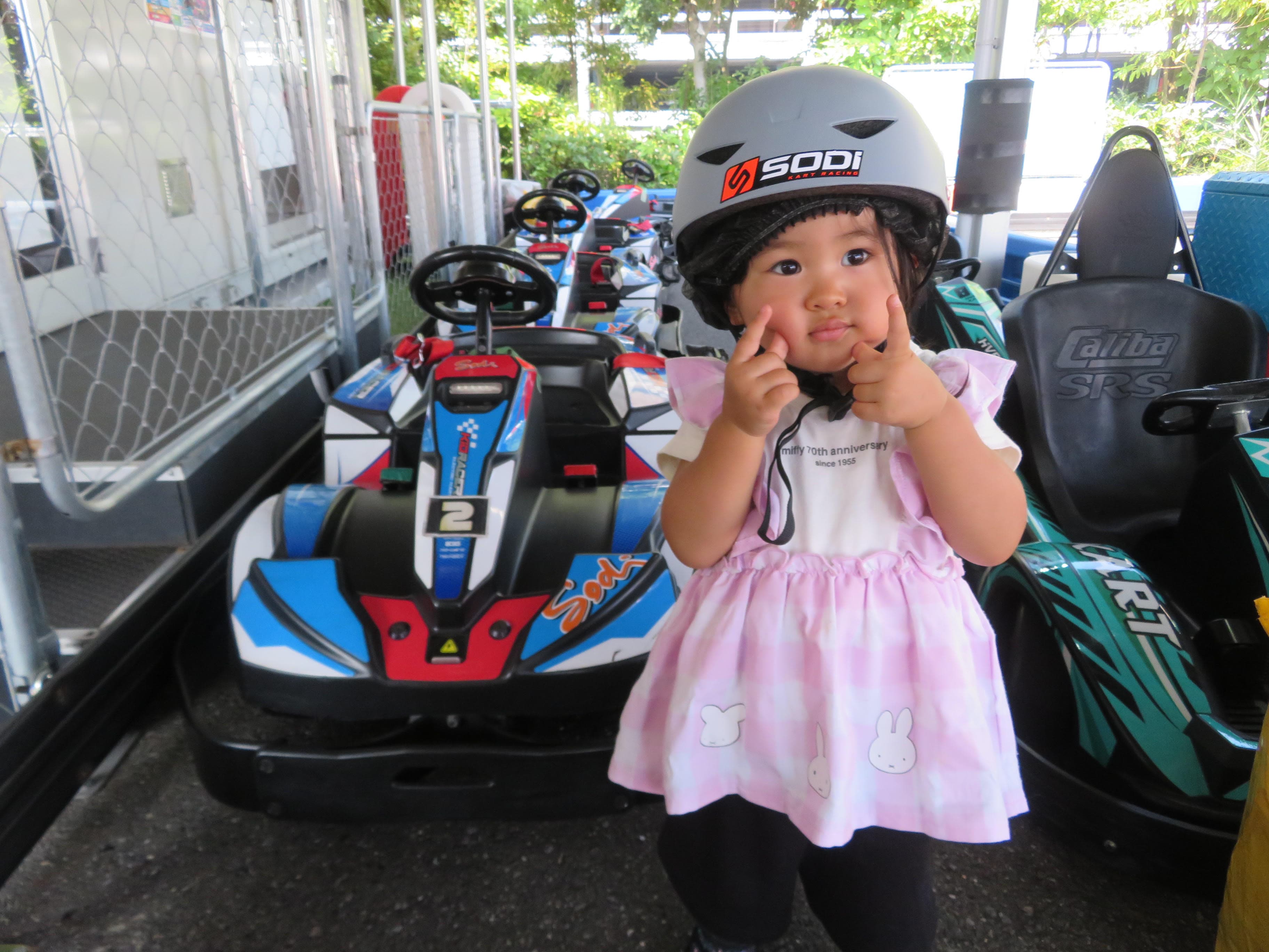 ヘルメットをかぶってキッズカートの前に立つ子ども
